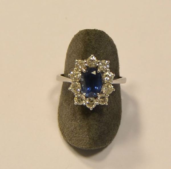 Anello in oro bianco, zaffiro e diamantial centro zaffiro ovale , con cornice in brillanti, g 4,6
