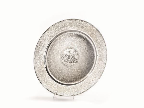   GRANDE PIATTO, SECOLO XX&nbsp;in argento di forma circolare,  piano e tesa decorati da volute vegetali, al centro entro riserva circolare scena amorosa, diam.cm 41, g 1080