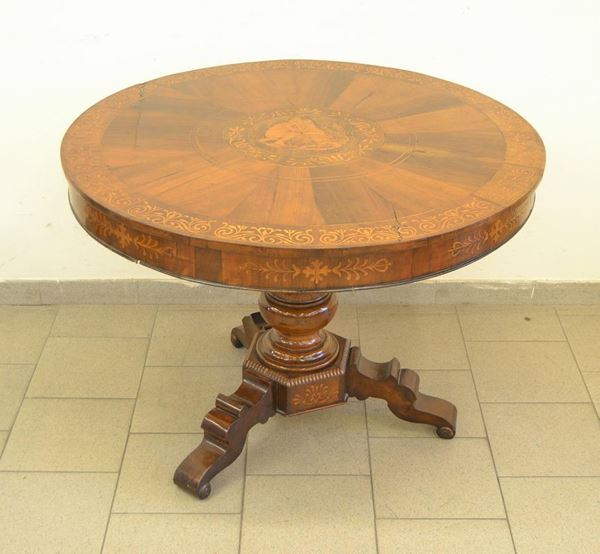 Tavolo, Italia meridionale, fine sec. XIX, in legno di frutto, intarsiato a motivi vegetali, al centro del piano busto di Garibaldi, fusto centrale a riccioli su tre piedi mossi, cm 120x127x77, difetti e rotture
