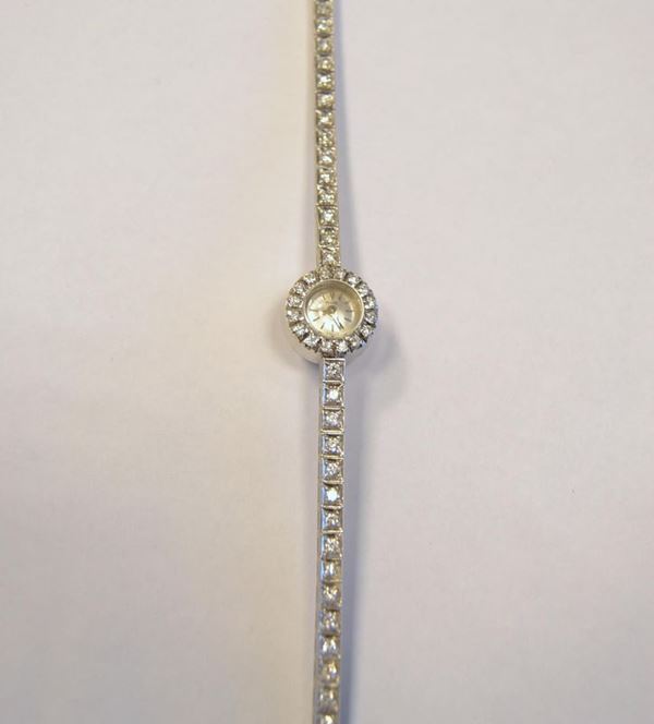      Orologio da polso per signora Piaget Ref 2301, n. 121512 , in oro bianco e diamanti,  cassa circolare in oro bianco con lunetta decorata da una fila di sedici brillanti, corona di carica sul fondello, quadrante argentè con indici applicati e lancette a spada. Movimento meccanico a carica manuale. Bracciale tipo 'tennis' in oro bianco realizzato ad una fila di quarantuno  brillanti per ct 2 circa montati entro castoni quadrati a griffe.