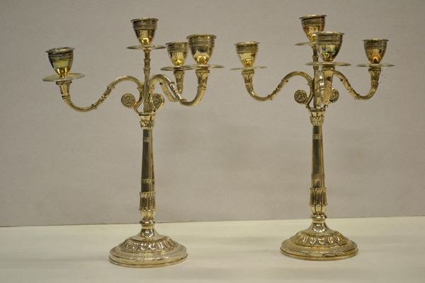 Coppia di candelabri, secolo XX, in argento ciascuno a quattro fiamme, basi
