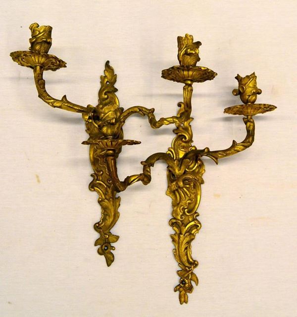 Coppia di appliques, sec. XIX, in bronzo dorato, foggiate a volute