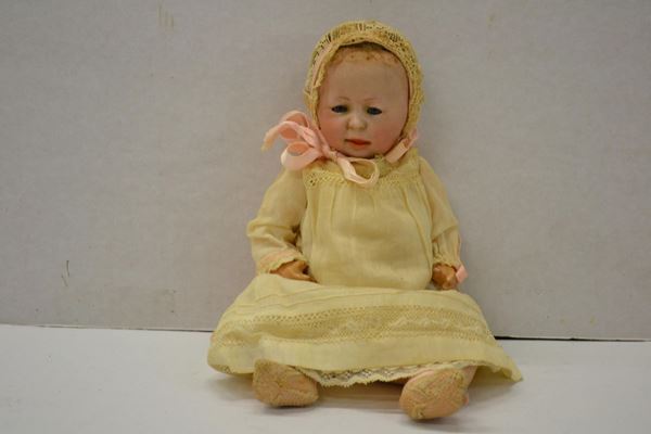 Bambola in bisquit, in forma di infante, inizi sec. XX, occhi mobili in vetro, con vestiti in lino ricamato, alt. cm 23, integra