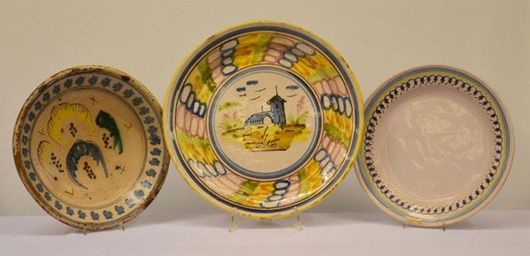 Tre piatti, sec. XIX, in maiolica decorata a paesaggi e