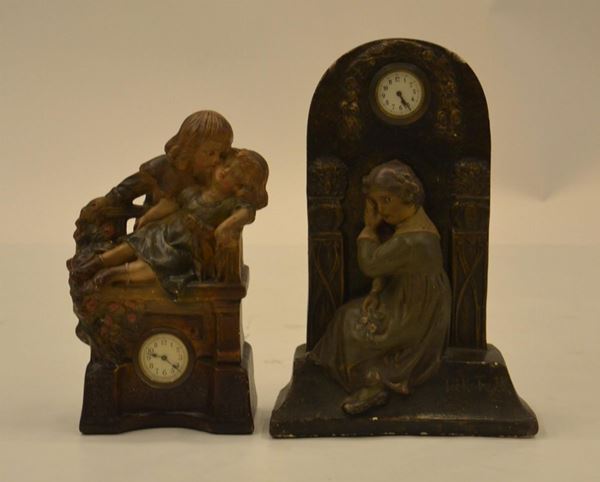 Due orologi da tavolo, sec. XX, in gesso con scultura&nbsp;&nbsp;&nbsp;&nbsp;&nbsp;&nbsp;&nbsp;&nbsp;&nbsp;&nbsp;&nbsp;&nbsp;&nbsp;&nbsp;&nbsp;&nbsp;&nbsp;&nbsp;&nbsp;&nbsp;&nbsp;