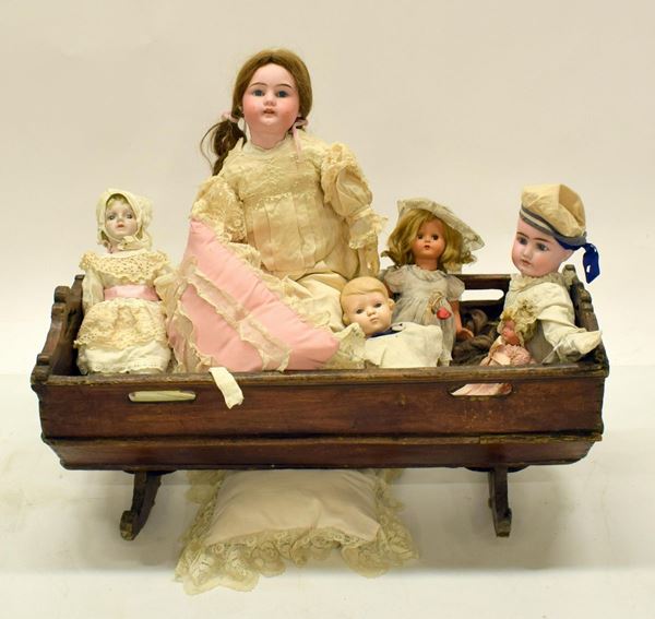 Culla in legno, con sei&nbsp; bambole, inizi sec. XX,