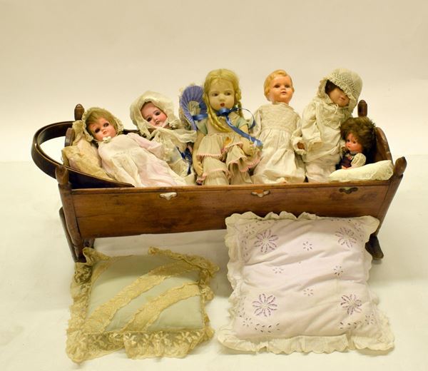 Culla in legno, con sei bambole, inizi sec. XX,