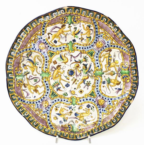 Piatto da parata, inizi sec. XX, in ceramica dipinta in policromia a grottesche, diam cm 34,5