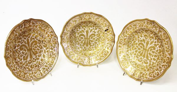 Tre piatti fondi, inizi sec. XX, in maiolica decorata a lustro nei toni del giallo, orlo mistilineo cordonato, diam. cm 24