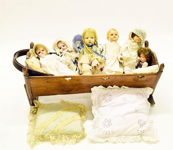 Culla in legno, con sei bambole, inizi sec. XX,