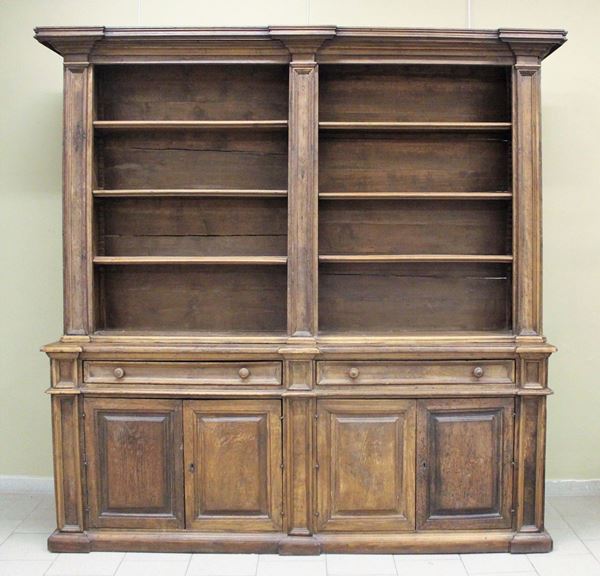 Libreria, in stile 600, in castagno, cimasa gradinata aggettante sottesa da scaffalatura a giorno a mensole regolabili in altezza, scandita da pilastri specchiati, corpo inferiore a due cassetti allineati e quattro sportelli accoppiati, piede a fascia, cm 230x50x236,costruita con materiale antico