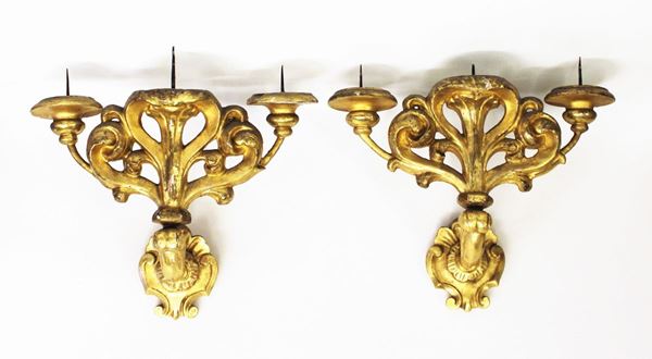 Coppia di appliques, sec. XVIII, in legno scolpito e dorato, tre bracci a volute, alt. cm 35