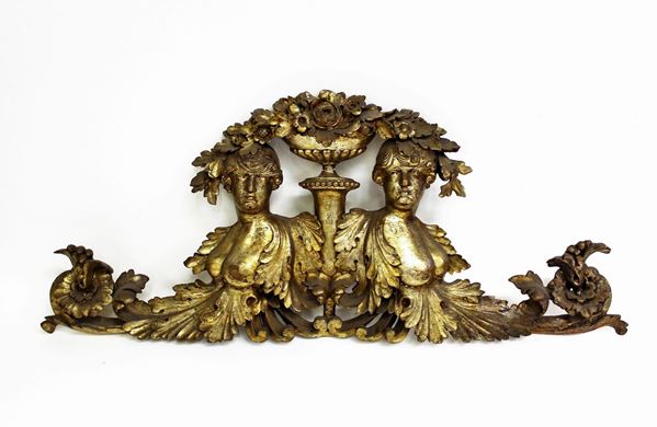 Fregio, sec. XIX, in legno intagliato e dorato a mecca, raffigurante coppia di busti muliebri, tra numerosi decori fitoformi, centrati da struttura vasiforme, cm 75x31