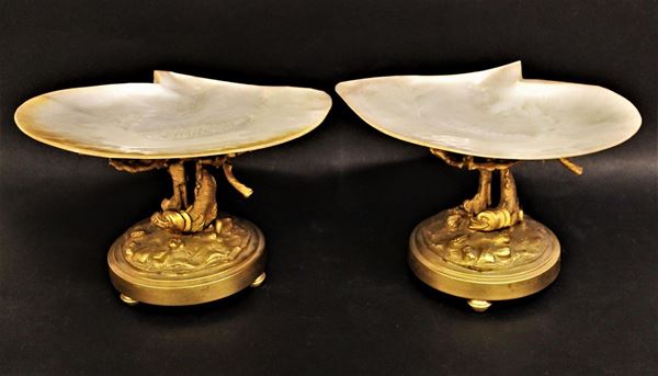 Coppia di alzate, inizi sec. XX, sostegno in bronzo dorato modellato a tritoni e motivi marini, piatti realizzato con valva di conchiglia madreperlacea, cm 15x25