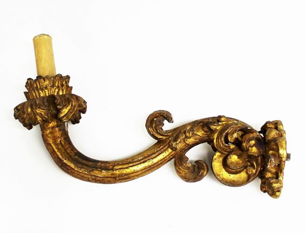 Braccio porta candela, sec. XVIII, in legno intagliato e dorato, sostegno a voluta decorato da motivi fitomorfi, cm 63