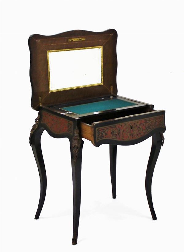Tavolino Boulle, fine sec. XIX, in legno ebanizzato intarsiato in tartaruga e bronzo, piano sagomato incernierato, all&#8217; interno specchio molato e piano a scrittoio, cassetto nella fascia a tutta lunghezza, gambe mosse rastremate, rapporti metallici, cm 62x42x72 difetti