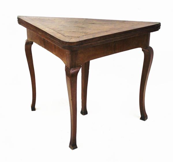 Tavolino da gioco Toscana, sec. XVIII, lastronato in noce, piano triangolare incernierato da aprirsi a libro, gambe mosse desinenti in piede a zoccolo, cm 105x58x79,5, difetti