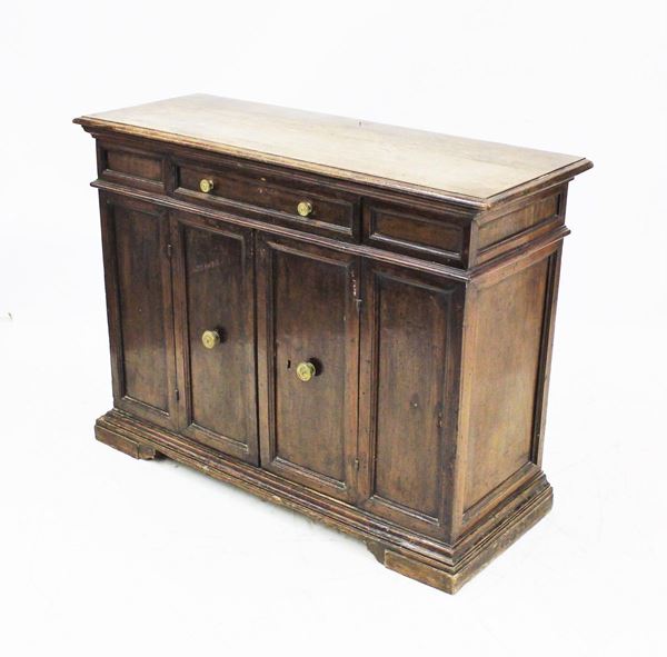 Credenza, sec. XVII, in noce, piano rettangolare a becco di civetta sotteso da cassetto centrato al fonte, due sportelli specchiati, piede a mensola, cm 132x 48x98, modifiche e restauri