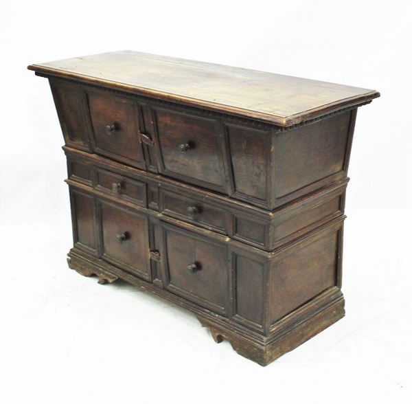 Credenza, sec. XVIII, in noce, piano rettangolare a becco di civetta sotteso da modanatura a dentelli incavi, fronte svasato a quattro sportelli intervallati da coppia di cassetti allineati, piede a mensola, cm 148x56x98, restauri e modifiche