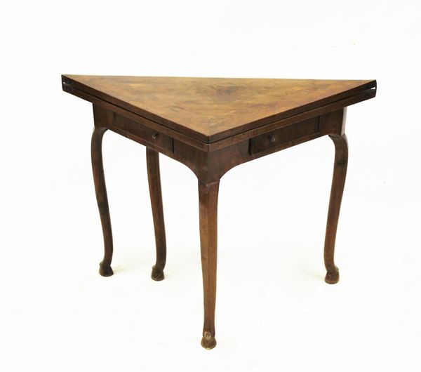 Tavolino da gioco, sec. XVIII, lastronato e filettato in noce, piano triangolare incernierato da aprirsi a libro, due tiretti nella fascia, gambe mosse desinenti in piede a zoccolo, cm 112x56x77,5