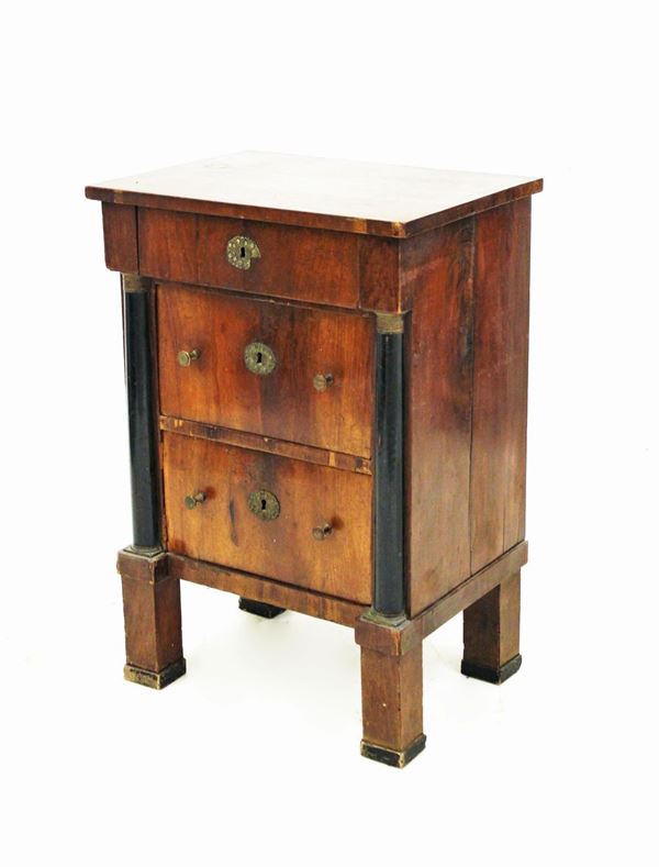 Comodino, Francia, Impero, in mogano, piano rettangolare sotteso da un cassetto, due cassetti in sottosquadro tra semicolonne ebanizzate desinenti in capitelli bronzei, piedi a plinto, cm 60,5x44,5x88