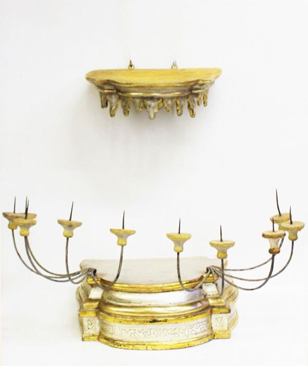 Tabernacolo, sec. XIX, in legno laccato, dorato e argentato, base sagomata intagliata a pi&ugrave; ordini in cui si innestano due reggicero ognuno a quattro bracci a voluta desinenti in bobeches lignee, reggicortina sagomata a lambrequin , cm base 50x36x18,5