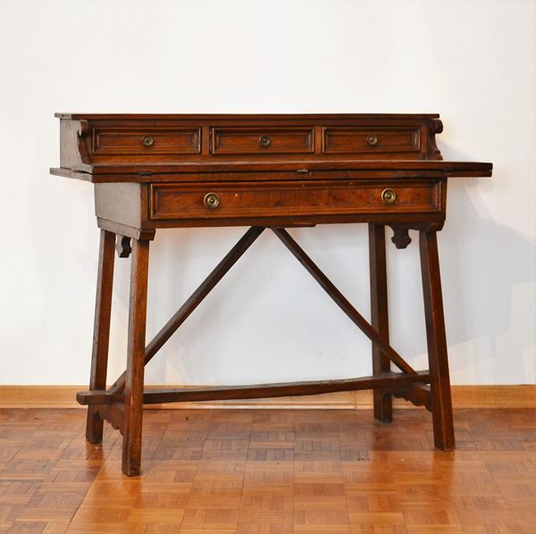 Scrivania, in stile 600, in noce, piano incernierato a ribalta, tre cassetti allineati e cassetto a tutta lunghezza sotto piano, gambe a capretta, cm 106x48x88
