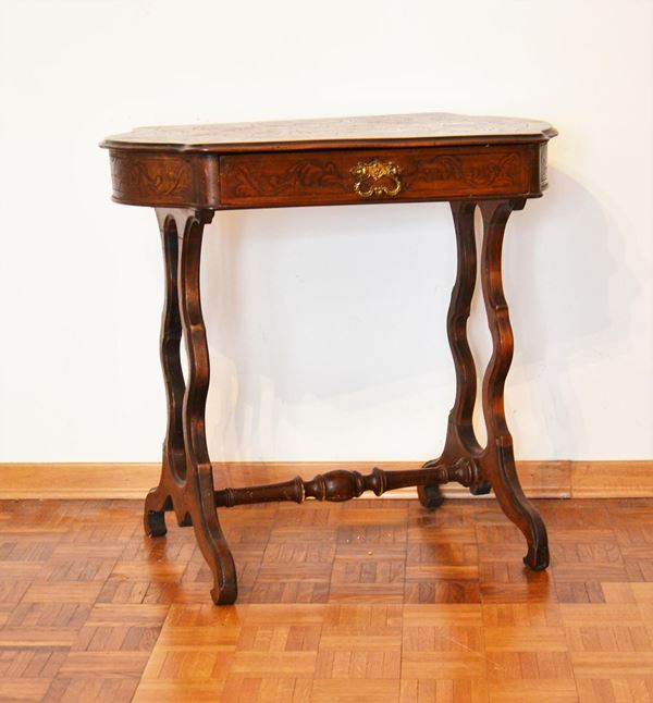 Tavolino, sec. XIX, in noce, piano sagomato e intagliato, cassetto nella fascia, sostegni mossi raccordati da traversa tornita, cm 78x49x70&nbsp;&nbsp;&nbsp;&nbsp;&nbsp;&nbsp;&nbsp;&nbsp;&nbsp;&nbsp;&nbsp;