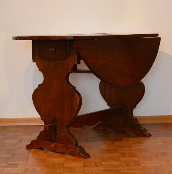 Tavolo a bandelle, sec. XIX, in noce, piano circolare, due cassetti sotto piano sostegni ad asso di coppe raccordate da traversa modanata, cm 122x54x80&nbsp;&nbsp;&nbsp;&nbsp;&nbsp;&nbsp;&nbsp;&nbsp;&nbsp;&nbsp;&nbsp;&nbsp;&nbsp;&nbsp;&nbsp;&nbsp;&nbsp;&nbsp;&nbsp;&nbsp;&nbsp;&nbsp;&nbsp;&nbsp;&nbsp;&nbsp;&nbsp;&nbsp;&nbsp;&nbsp;&nbsp;&nbsp;&nbsp;&nbsp;&nbsp;&nbsp;&nbsp;&nbsp;&nbsp;&nbsp;&nbsp;