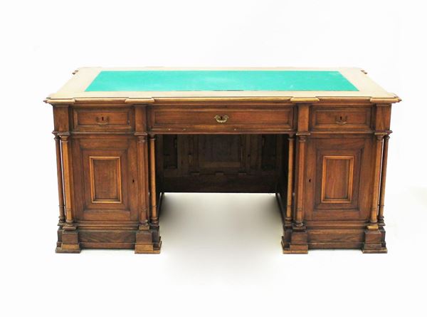 Scrivania ministeriale da centro, sec. XIX/XX, in rovere, piano a linea spezzata, rivestito con panno verde, sotteso da tre cassetti allineati, montanti a sportello celanti coppia di cassetti, struttura scandita da colonnine tornite, piede a fascia, cm 172x95x80