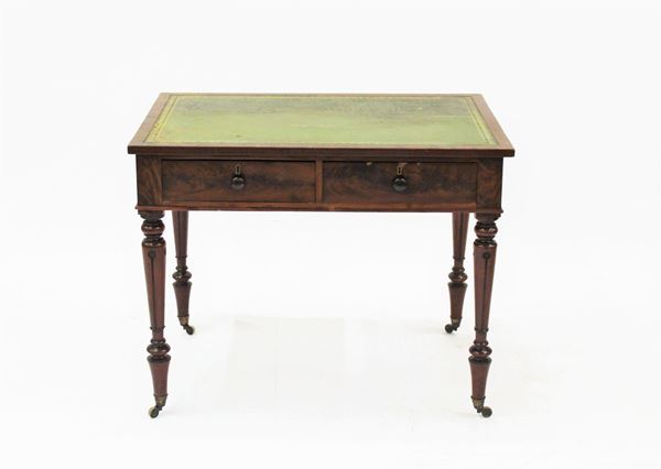 Scrittoio, fine sec. XIX, in mogano e piuma di mogano, piano rettangolare rivestito in pelle verde, sotteso da due cassetti allineati nella fascia, gambe tornite e intagliate desinenti su rotelle metalliche, cm 91,5x60x72,5