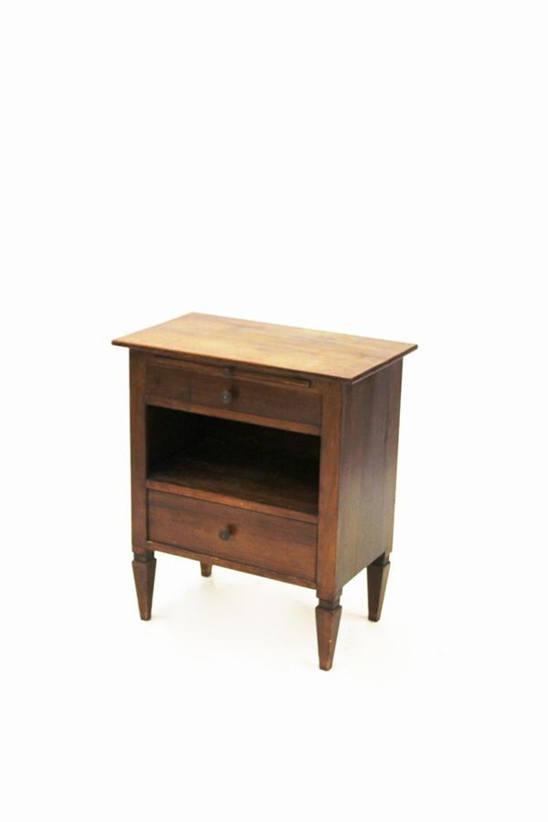 Comodino, sec. XIX/XX, in noce, piano rettangolare sotteso da tavoletta estraibile, due cassetti intervallati da vano a giorno, gambe troncopiramidali, cm 68x40x79