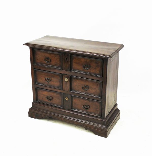 Cassettone, sec. XVII, in noce, piano rettangolare a becco di civetta, fronte a tre cassetti doppia a riserva rettilinea nervata, fianchi lisci, piedi a mensola, cm 95,45x87,5 , modifiche