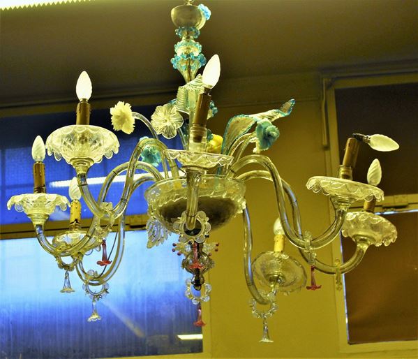 Lampadario, Murano, sec. XX, in vetro incolore e policromo, nove&nbsp; luci disposte su bracci ricurvi, intervallati a foglie e fiori policromi di diversa foggia, alt. cm 100 diam. cm 80, difetti, mancanze e sostituzioni