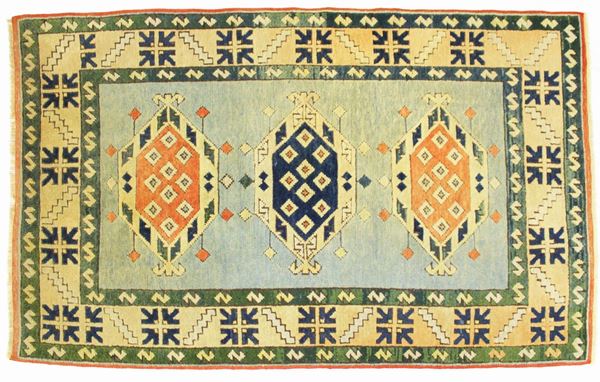 Tappeto, Caucaso, sec. XX, impianto geometrico, campo nei toni del celeste a tre medaglioni, cm 200x118