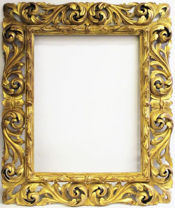 Cornice, sec. XX, in legno dorato e intagliato ad ampie volute contrapposte, cm 102x78, luce cm 69x55