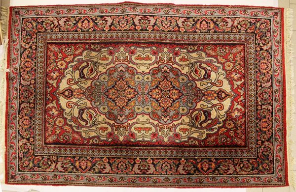 Tappeto persiano, sec. XX, nei toni del rosso, medaglione centrale su campo avana, cm 304x190