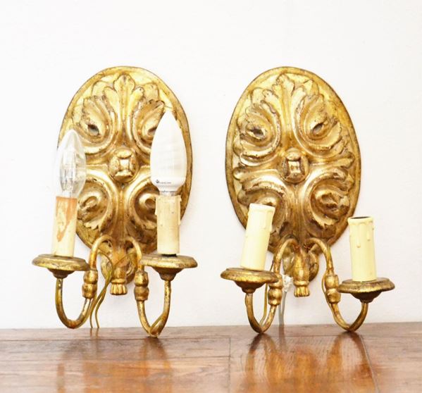 Coppia di applique, in stile 700, in legno intagliato e dorato due luci, cm