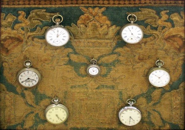 Sette orologi da tasca entro cornice, sec. XIX, cm 49x45                  