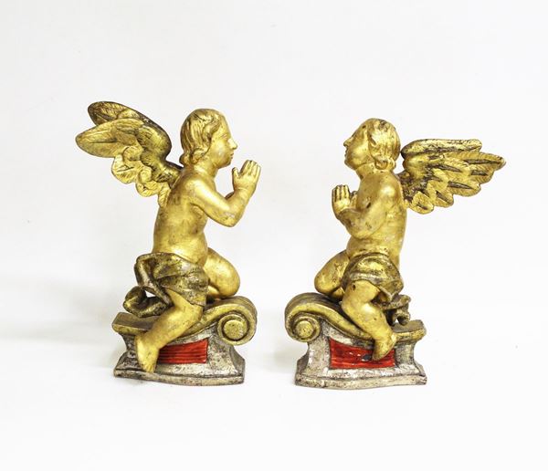 Coppia di angeli genuflessi, sec. XVIII, in legno intaglaito dorato e     