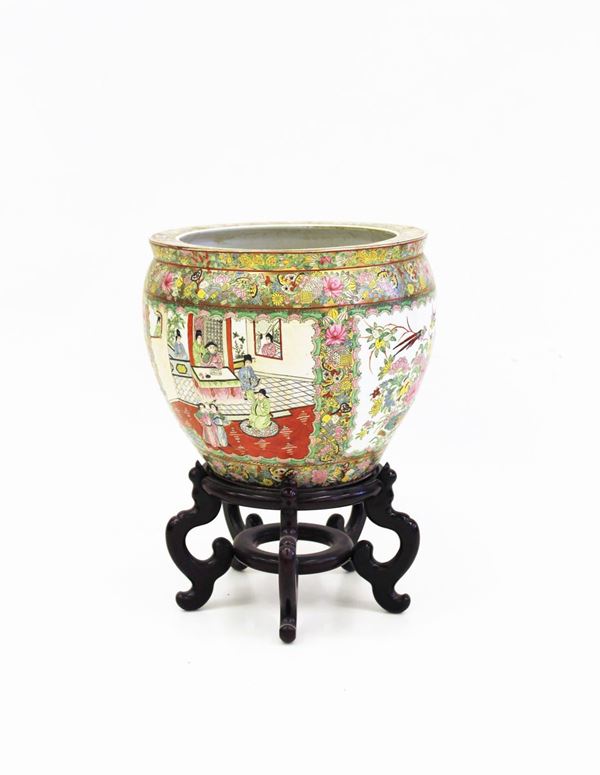 Vasca da pesci, Cina, sec. XX, in porcellana lumeggiata in oro e dipinta in policromia ad ampie riserve figurate alternate a riserve a motivi florofaunistici, interno decorato a motivi ittici, su base in legno, diam. cm 40, alt. cm 56
