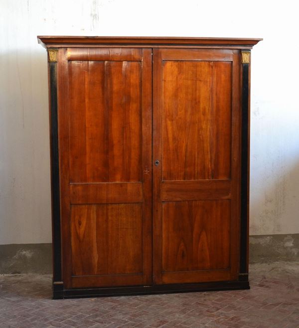 Armadio, tardo impero, sec. XIX, in noce, laterali con colonne ebanizzate e finali dorati, cm 166x58x195