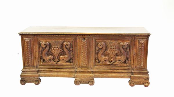 Cassapanca, sec. XVIII, in noce, piano da alzarsi, fronte a due formelle ricchemente intagliate a tritoni e paniere fruttate scandite da riserve intagliate a cancorrente, maniglie metalliche sui fianchi, piedi a zampa ferina, cm 150x55x65