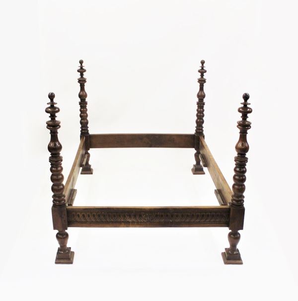 Letto, in stile 600, in noce, montanti intagliati a motivi baccellati, colonne tornite a motivi vasiformi, piedi a plinto, cm 210x151x140