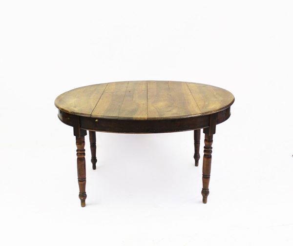 Tavolo allungabile, sec. XIX, in noce piano ovale, gambe tornite, cm 139x110x75, due allunghe