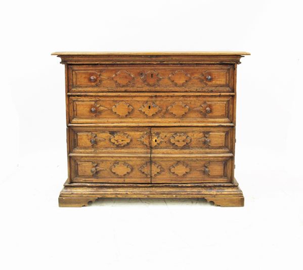 Cassettone, Lombardia, sec. XVIII, in noce, piano rettangolare a becco di civetta, sotteso da due cassetti a tutta lunghezza e due sportelli scolpiti a bugne mistilinee, piede a mensola, cm 132,5x55x106, difetti e modifiche