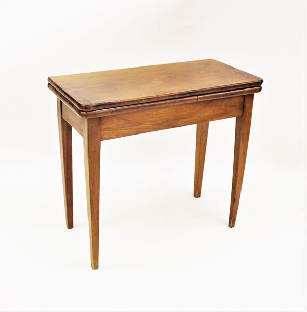 Tavolo da gioco, sec. XIX, in noce, piano incenierato a ribalta,&nbsp; gambe troncopiramidali rastremate, chiuso cm 81x40x72, difetti