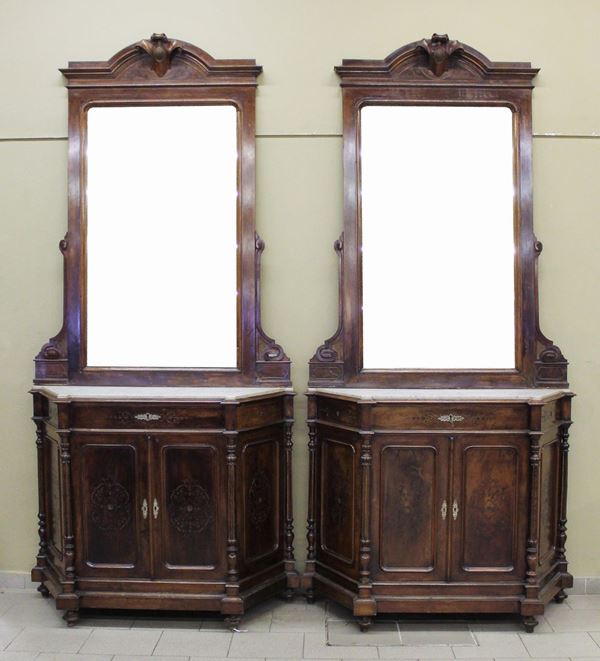 Coppia di credenze, fine sec. XIX, in noce, piano in marmo, fronte scantonato ad un cassetto e du e sportelli tra semicolonne, specchiere a luce rettangolare, cimase mistilinee, piedi a trottola, cm 124,5x50x260