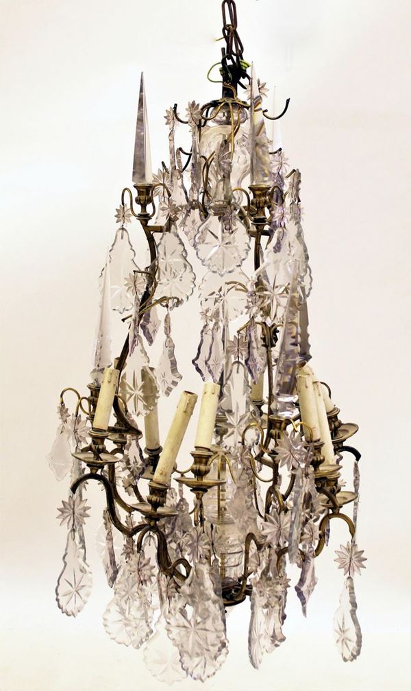 Lampadario, sec. XIX, in metallo dorato a nove luci, applicazioni in cristallo molato, alt. cm 100, diam. cm 60, difetti e mancanze