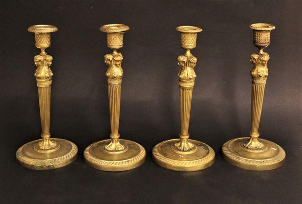 Quattro candelieri, fine sec. XIX, in bronzo dorato, fusti a cariatidi egizie, basi circolari, alt cm 24,5, simili tra loro (4)